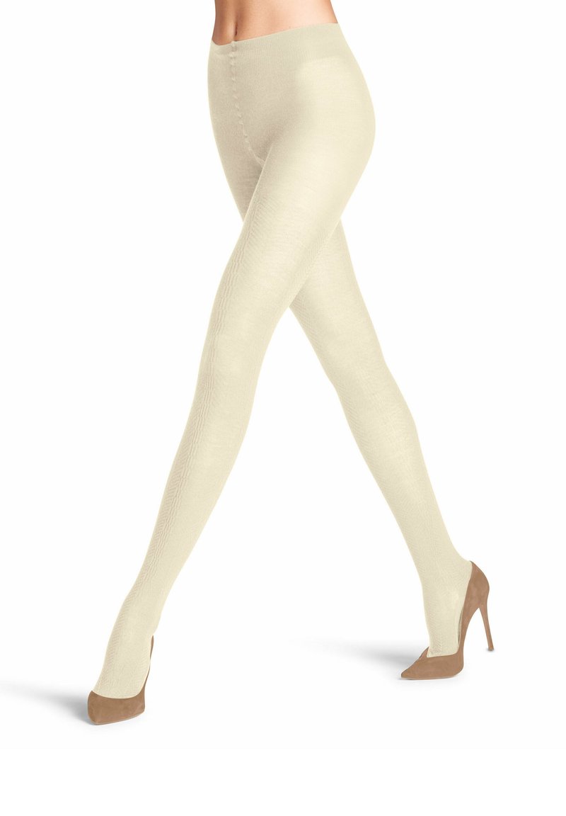 Collant crema con trama e finitura liscia, caratterizzati da un alto talle e un design aderente, abbinati a scarpe con tacco nude.