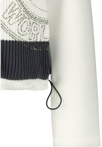 Stickad tröja med en färgskala av vitt och mörkgrått, med en strukturerad kropp och släta vita ärmar, försedda med dekorativa nitar.