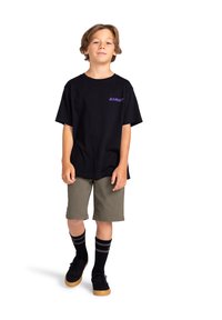 Camiseta negra de manga corta con la palabra "ELEMENT" en letras moradas, pantalones cortos caqui, calcetines negros con rayas y zapatillas negras con suelas de goma.