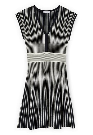 Zwart-witte mouwloze jurk met verticale strepen, V-hals en horizontale gestreepte tailleband detail.