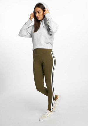 Grijze hoodie met een trekkoord en kangoeroezak, gecombineerd met olijfgroene leggings met witte zijstrepen en een gladde textuur.