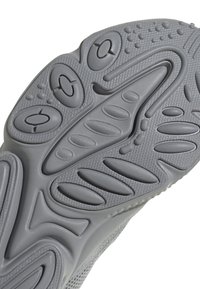 Suola grigia di scarpa in gomma multistrato, con motivi arrotondati, creste e ritagli circolari per migliorare la trazione e la flessibilità.