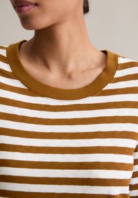 Gestreept top met afwisselend bruine en witte horizontale strepen, een geribde ronde halslijn en zachte katoenen stof.