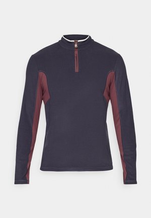 Temno modra pulover s dolgimi rokavi in maroon stranskimi paneli ter ovratnikom z četrtim zadrgo, ki ima majhen srebrn ročaj.