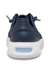 Zapatillas Crocs de color azul marino con parte superior texturizada, cordones elásticos y suela blanca con una ventana de acento azul. Diseño sencillo y material ligero.