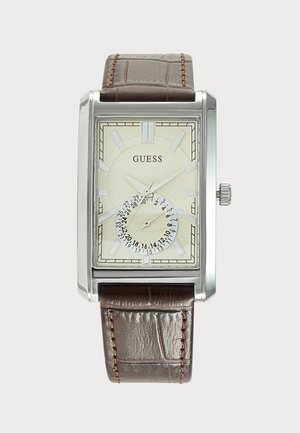 Montre rectangulaire argentée avec cadran crème, index des heures argentés, sous-cadran de date et bracelet en cuir marron avec surpiqûres.