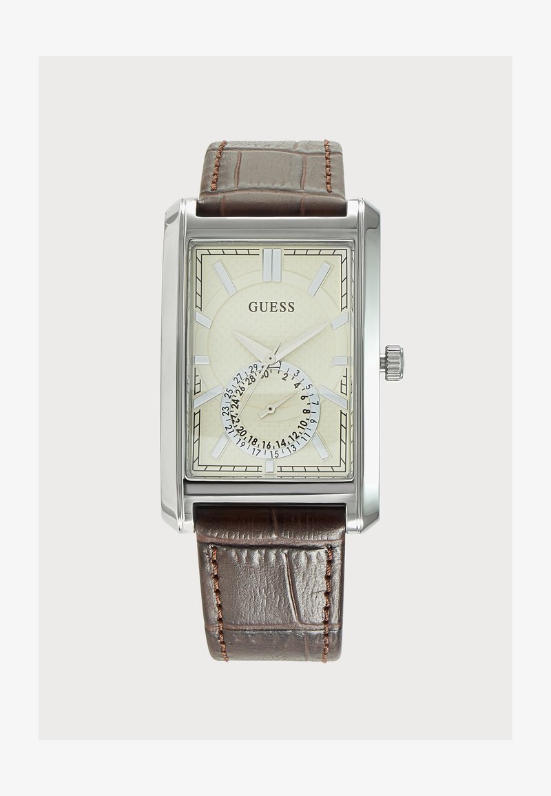 Montre rectangulaire argentée avec cadran crème, index des heures argentés, sous-cadran de date et bracelet en cuir marron avec surpiqûres.