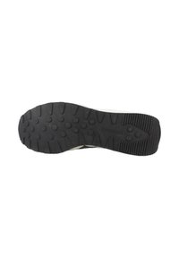 Suela negra de goma de un zapato Reebok con patrones circulares y lineales para agarre y estabilidad.