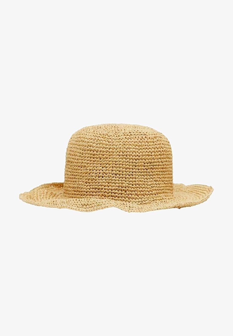 Chapeau de paille beige à large bord, couronne arrondie et bord légèrement ondulé, présenté sur fond blanc.