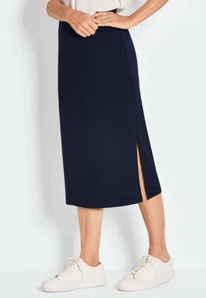 Jupe midi navy avec fente sur le côté, fabriquée dans un tissu doux et extensible. Design droit, avec un ourlet lisse. Associée à des baskets blanches.