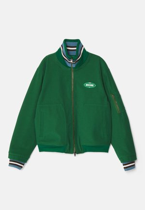 Zelená zapínacia bunda vyrobená z mäkkej tkaniny, s vysokým golierom a pruhovanými akcentmi, dvoma prednými vreckami a značkovou nášivkou.