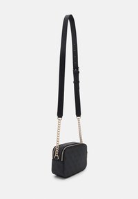 Bolso compacto negro con forma rectangular, material texturizado, Hardware dorado y una correa de cadena; cuenta con un doble cierre de cremallera.