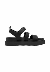 Svarta sandaler med breda remmar, tillverkade av matt syntetmaterial. Har en platt sula med en texturerad yta och en bakre hälögla.