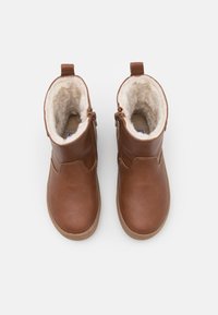 Bottines en cuir marron avec une finition texturée, doublure en laine, zips sur les côtés et une semelle en caoutchouc tan durable.
