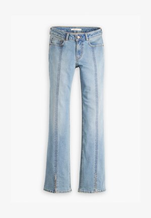 Svijetloplave traperice s zvonolikim krojem i visokim strukom, prednjim džepovima i vidljivim šavovima. Noge imaju dizajn s razdvojenim rubom.