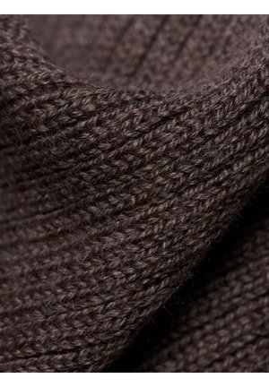 Brązowa dzianina o teksturowej powierzchni, prezentująca grube, splątane włókna przędzy i lekko puszysty wygląd.