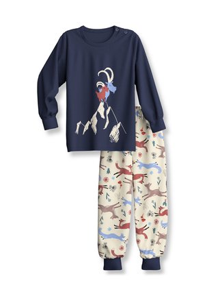 Haut bleu marine à manches longues avec imprimé montagne et chèvres, associé à un pantalon crème avec des motifs multicolores d’animaux et de plantes.