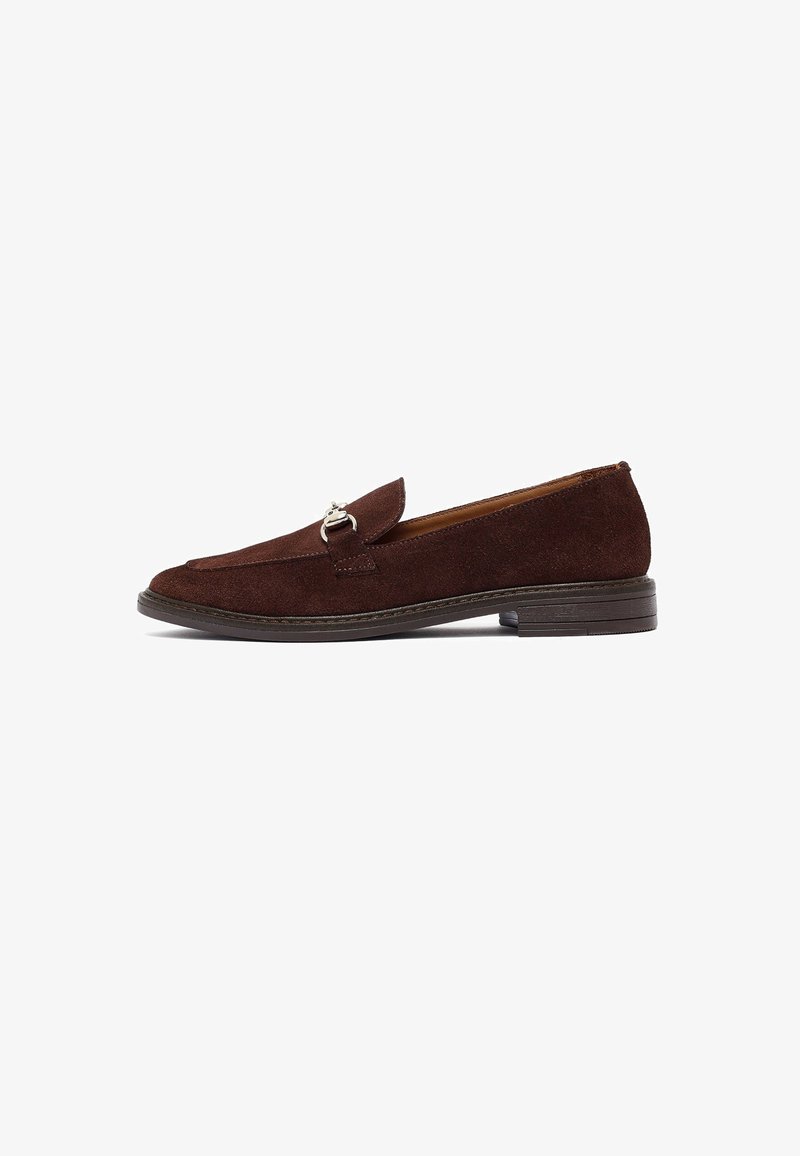 Mocassins en daim marron foncé pour homme avec un détail de boucle en argent et un petit talon empilé, présentés en profil latéral sur un fond blanc.
