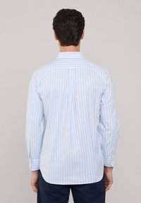 Camicia a maniche lunghe a righe azzurro chiaro e bianco con colletto button-down, caratterizzata da una piega sul retro e polsini a un bottone.