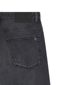 Jeans in denim grigio scuro con una tasca posteriore che presenta un piccolo logo e un'etichetta in pelle nera liscia sulla cintura.