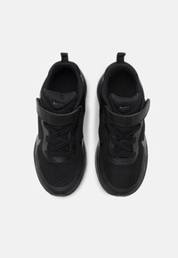 Chaussures de sport noires avec une tige en mesh, design à lacets, col rembourré et semelle en caoutchouc ; elles présentent un petit logo sur la languette.