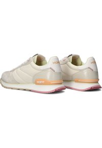 Zapatillas deportivas de color beige claro con una mezcla de materiales lisos y texturizados. Presentan acentos en naranja y una suela rosa. Logo en el talón.