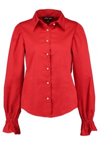 Blouse rouge à manches longues avec boutons en perle, épaules bouffantes, poignets froncés et col pointu, taille petit, marque Sister Jane.