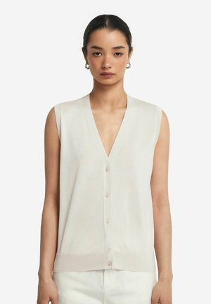 Lys beige, ærmeløs cardigan med V-hals, der har knaplukning og ribbet kant. Fremstillet af et blødt, struktureret materiale.