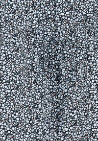 Schwarzer Stoff mit einem verstreuten pastellfarbenen Blumenmuster. Verfügt über einen Kordelzug in der Taille und hat eine leichte Textur, ideal für warmes Wetter.