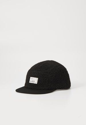 Black fleece cap with a textured, plush body and a flat black brim. Features a small label on the front. Rounded shape.