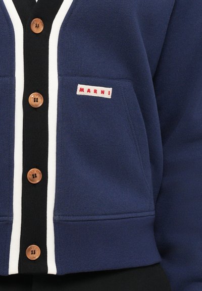 Navy blue cardigan with black and white trim, wooden buttons down front, and a small label reading "MARNI" on the left pocket.