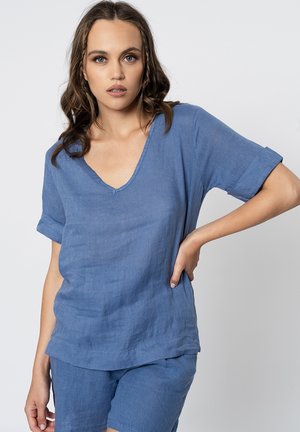 Haut en lin bleu clair avec des manches courtes retroussées, un décolleté en V et une coupe décontractée. Assorti avec un short, mettant en valeur un tissu texturé.