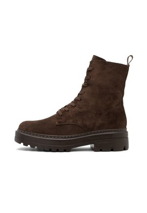 Bruine suède enkelboots met een vetersluiting, platte chunky zool, versterkte stiksels en een lipje aan de achterkant.