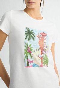 Valge lühikese varrukaga T-särk, millel on värvikas Miami graafika palmipuudega, retro silt ja rulluisija kujutis.