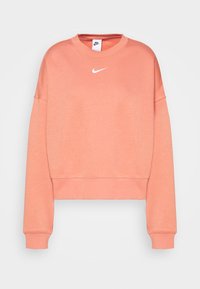 Ljus korallfärgad kortärmad sweatshirt tillverkad av mjukt tyg. Har långa ärmar och en vit Nike-logotyp på bröstet. Ribbad muddar och halsringning.