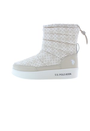 Beige nilkkurit, joissa on tikattu päällinen valkoisella kuviolla, valkoinen pohja ja sivulogo. Sisältää vetoketjun ja säädettävän narun.