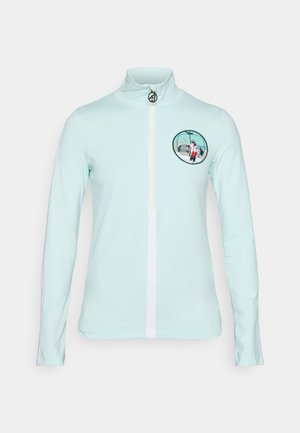 Himmelblaues Langarmoberteil mit hohem Kragen, Frontreißverschluss und einem bestickten kreisförmigen Design mit einer sitzenden Figur. Weiße seitliche Akzente.