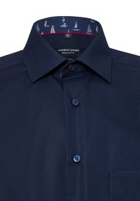 Marineblaue Hemd mit regulärem Schnitt, ausgestattet mit einem gemusterten Innenkragen, dunklen Knöpfen und einer Tasche auf der linken Seite.