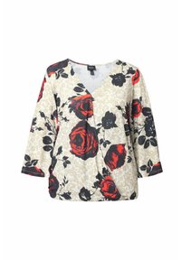 Květinová blůza s béžovým pozadím, zdobená velkými červenými a černými růžemi, s výstřihem do V a rukávy po třičtvrtě. Měkká tkanina, mírně řasený design.