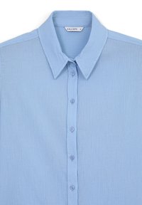 Himmelblaues Button-up-Hemd aus strukturiertem Stoff mit einem normalen Kragen und sechs Knöpfen auf der Vorderseite. Mit einem Etikett versehen, das "CALLIOPE" trägt.