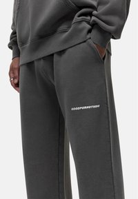 Grijze joggingbroek van een zachte stof, met zijzakken en het "GOODFORNOTHING" logo in het wit op de linker dij. Ontworpen met een relaxte pasvorm.