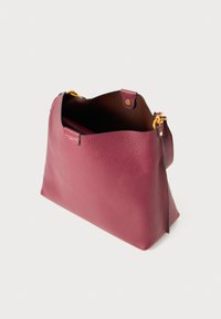 Borsa a mano in pelle bordeaux con superficie morbida e texture, apertura superiore e hardware in tonalità oro. L'interno presenta un rivestimento scuro a contrasto.