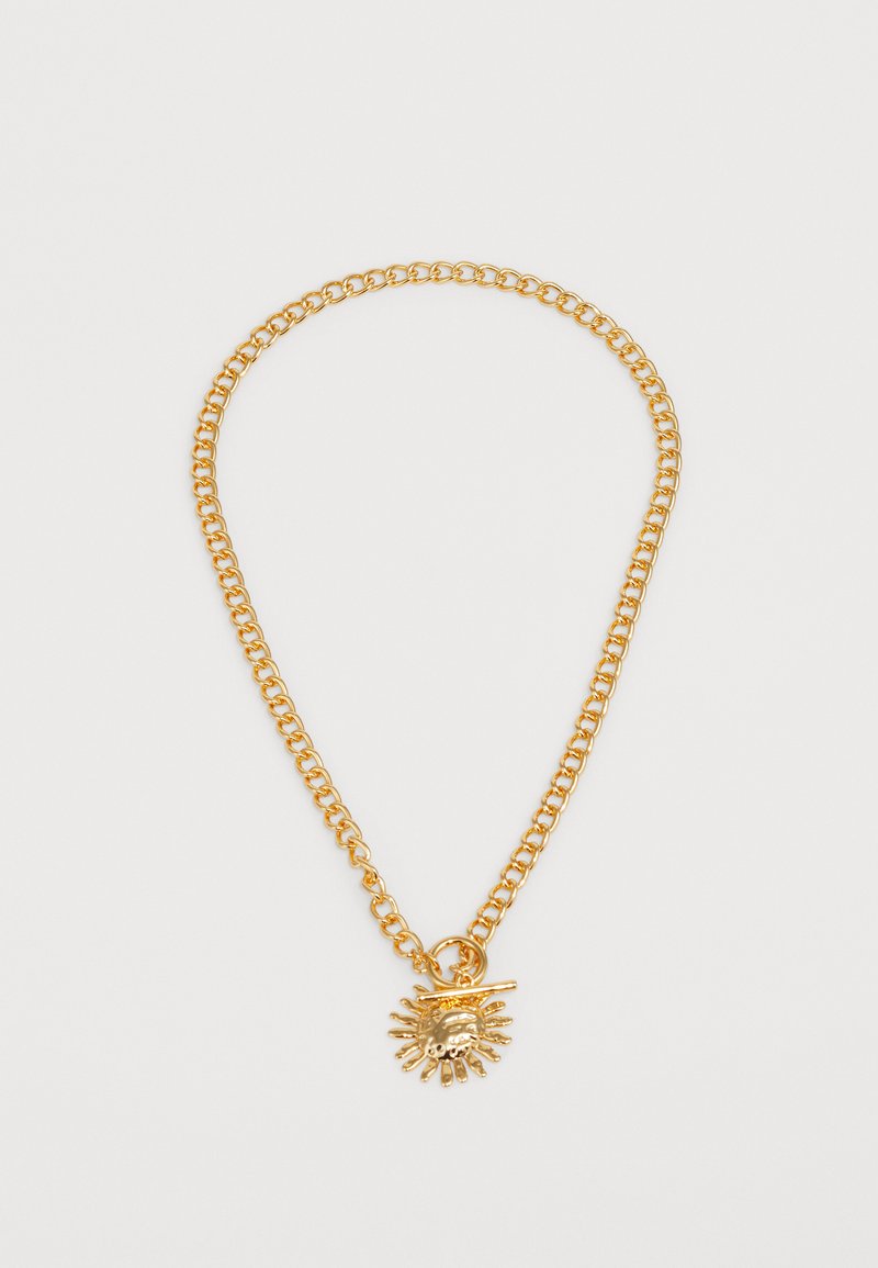 Zlato obarvana verižica z obeskom v obliki sonca, ki ima podrobne žarke, gladko teksturo in povezovalno opremo.
