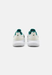 Zapatillas deportivas blancas con parte superior de malla, acentos en azul verdoso y suela texturizada. Incluyen un collar acolchado y el logo característico en el talón.