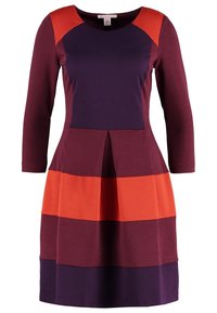 Sukienka w kolorze bordowym, granatowym i pomarańczowym z długimi rękawami, okrągłym dekoltem oraz poziomym wzorem w blokach kolorowych. Detal w postaci talii w fałdy. Materiał mieszanka bawełny.