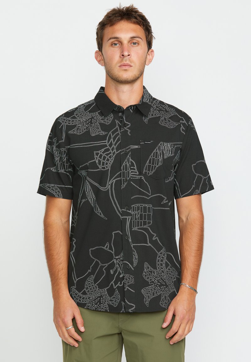 Camisa negra de manga corta con patrones de contorno en blanco de flores y hojas; diseño de botones en la parte delantera y bolsillo de parche en el lado izquierdo.