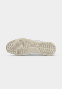 Σόλα λευκού παπουτσιού Reebok με υφή για καλύτερη πρόσφυση και το λογότυπο Reebok χαραγμένο στο κέντρο.