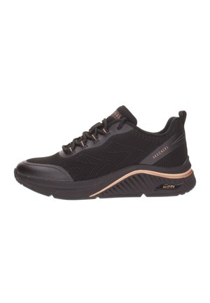 Baskets de sport noires avec une tige en mesh, design texturé, bout arrondi et accents dorés sur la semelle. Comprend la technologie ArchFit pour le soutien.