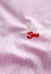 Pink fabric with vertical blue stripes, featuring a red embroidered lobster design. Soft texture with a lightweight, smooth finish.