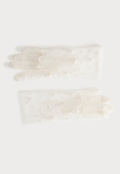 Paire de gants blancs en tulle ornés de petites perles semblables à des perles, éparpillées sur le tissu, posée à plat sur une surface blanche.